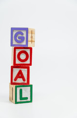 GOAL word wooden block arrange in vertical style on white background and selective focus