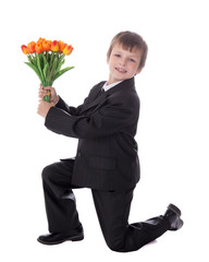 side view of little boy in business suit giving flowers to someb