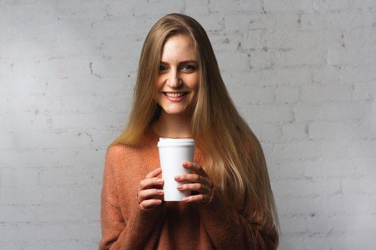 Joyful girl poses with a coffee cup.