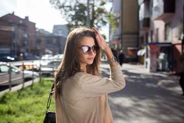 Fototapeta premium Young pretty woman outdoor fashion portrait. Beautiful girl casual dress and sunglasses