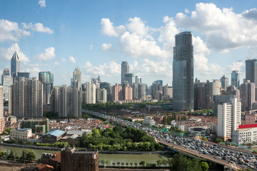 shanghai highway overpass with modern city skyline against a sunny sky , China