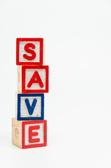 SAVE word wooden block arrange in vertical style on white background and selective focus