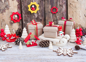 Christmas or New Year background: fur-tree, branches, gifts, colored glass balls, decoration and cones on wooden background