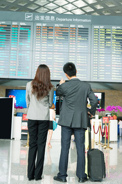 back of long hair girl and businessman in airport