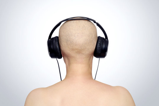Bald female head with headphones, rear view. File contains a path to isolation. 