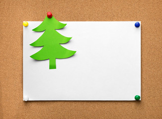 Christmas tree made of green paper and blank sheet on the cork b