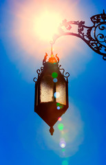 silhouette of old lantern hanging in bright sunlight