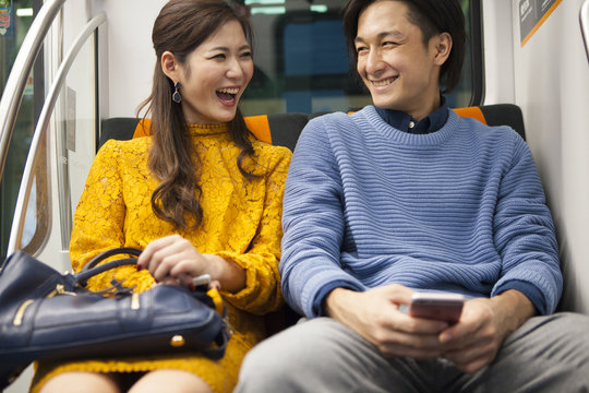 The couple laughing happily in the train