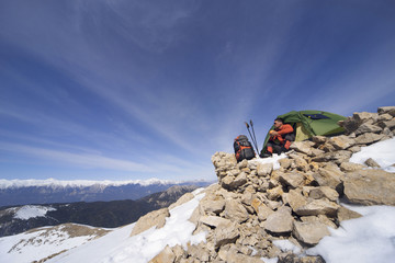 Winter camping in the mountains with a backpack and tent.