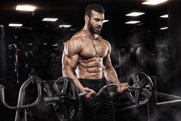 Fototapeta na wymiar Handsome man with big muscles, posing at the camera in the gym