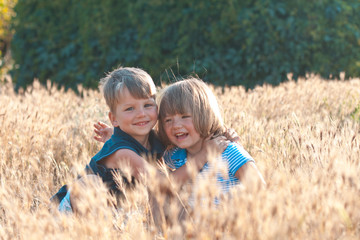 Joyful kids together on the field in the summer