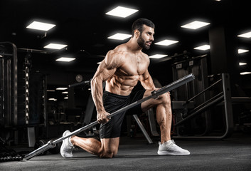 Fototapeta na wymiar Handsome man with big muscles, posing at the camera in the gym