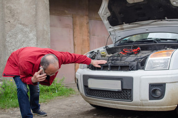 Aged man fixing the car