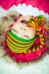 Positive girl in the colorful hat on the snow