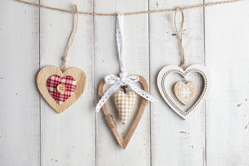 Wooden valentine hearts hanging over white fence