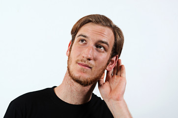 A Young Adult Male Wearing Dark T-Shirt with His Hand Near His Ear. Gestures Can Not Hear or Talk Louder.