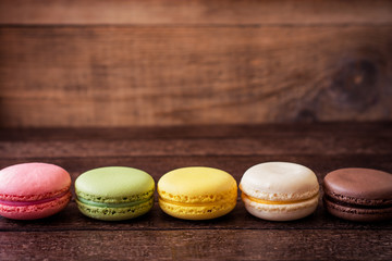 Colorful macarons on dark wooden background