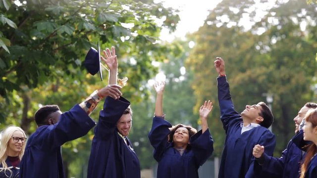 happy students throwing mortar boards up