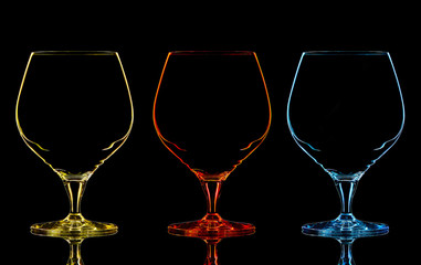 Silhouette of color whiskey glass on black background.