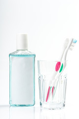 Toothbrushes in glass on table on light background