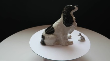 two porcelain statuettes dogs on a rotating table