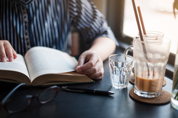 Woman reading book in cafe