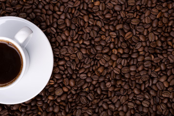 half of cup of coffee on background made of coffee beans