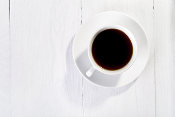 white cup of coffee on white wooden background