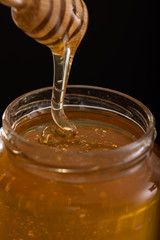 Close-up of a jar of honey with wooden dipper 2