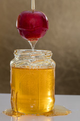 Jar of honey on color background with an apple 2