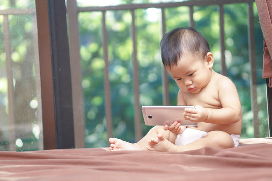 Asian Baby Playing Mobile Phone