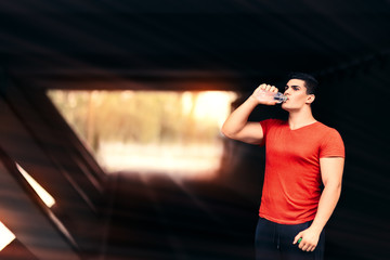 Athletic Man Drinking Water and Resting from Fitness Routine