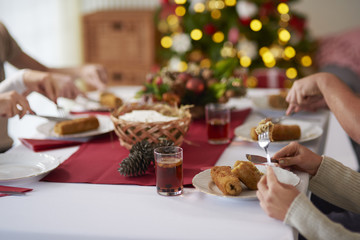 Fototapeta na wymiar People eating croquette over Christmas table