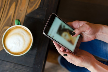 Young woman with coffee and phone