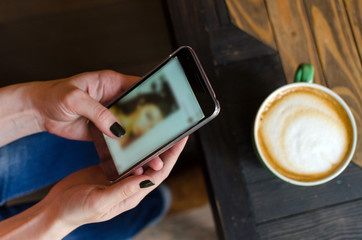 Young woman with coffee and phone