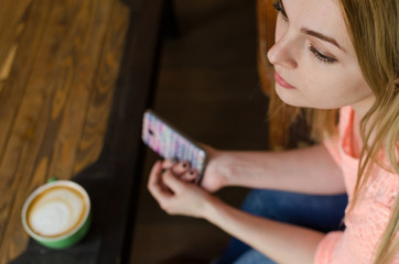 Young woman with coffee and phone