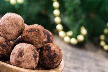 Christmas chocolate truffles and Christmas decoration on wooden table

