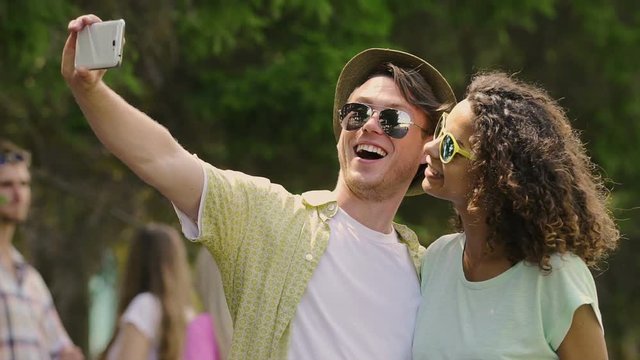 Carefree young people enjoying summer holidays, taking selfie on smartphone