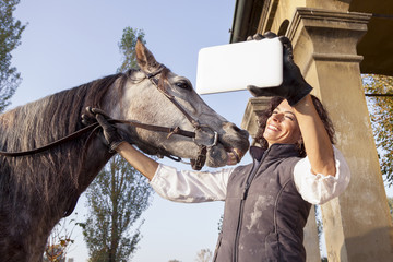 horsewoman takes a selfie with his horse to the country roads in