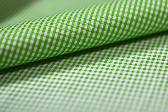 close up roll green and white scott pattern fabric of shirt