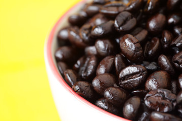 coffee bean in coffee cup with yellow background.
