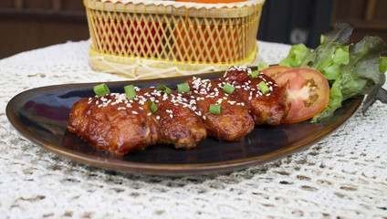 Baked chicken wings in honey sauce sprinkled with sesame seeds.