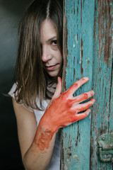 Ghost woman behind vintage wooden door, blood covered hand