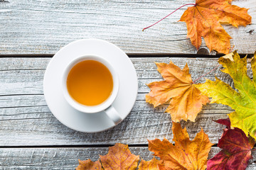 Cup of tea with autumn leaves.