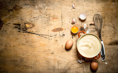 Mayonnaise in bowl with ingredients for cooking.