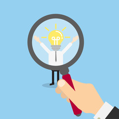 Hiring staff concept. Hand with magnifying glass finding and recruiting new worker. Man with lightbulb head.