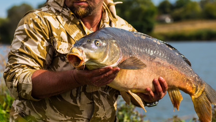 Obraz premium Happy angler with carp fishing trophy