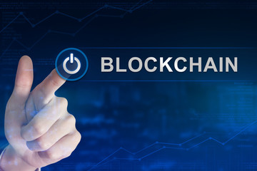 business hand clicking blockchain button