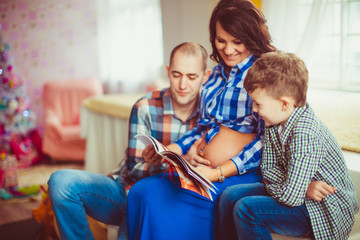 Joyful family reads a book while sitting in cosy room