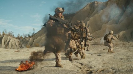  Soldiers Carrying Injured One While other Members of Squad Covering Them During Military Operation in the Desert. Slow Motion. Shot on RED EPIC Cinema Camera in 4K (UHD).